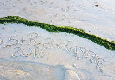 High angle view of text on sand at beach