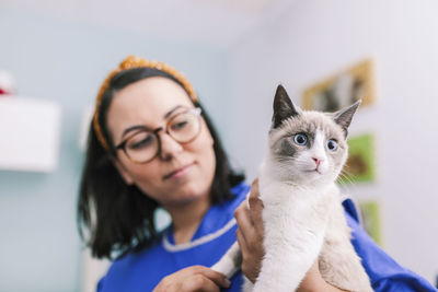 Woman holding cat at animal hospital