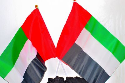 Close-up of flags hanging against white wall