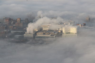 Smoke emitting from factory against sky