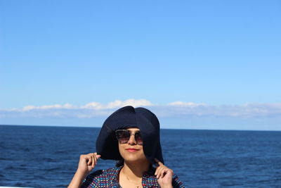 Portrait of young woman in sea against sky