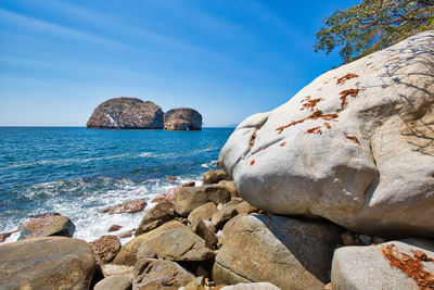 Rocks on beach against sky