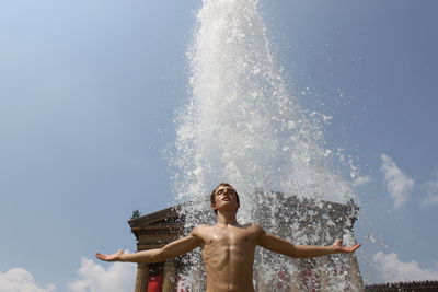Low angle view of shirtless man standing against philadelphia museum of art