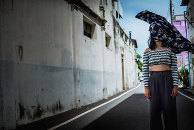 Rear view of woman walking on road in city