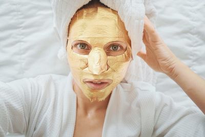 Portrait of woman with golden facial mask