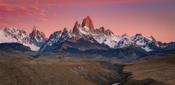 Scenic view of snowcapped mountains against sky during sunset