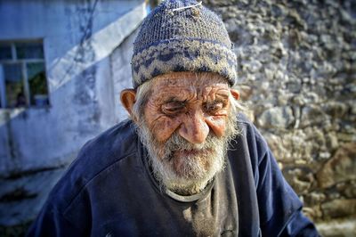 Bearded senior man against wall