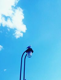 Low angle view of street light against blue sky