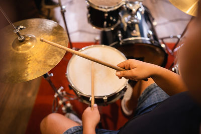 Midsection of man playing drum