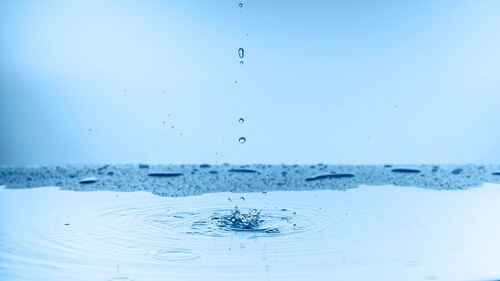 Close-up of splashing water against blue sky