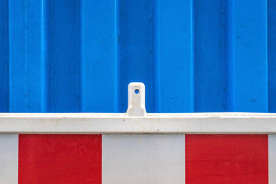 Close-up of bird perching on blue wall