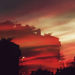 Silhouette city against sky during sunset