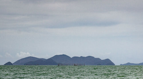 Scenic view of sea and mountains against sky