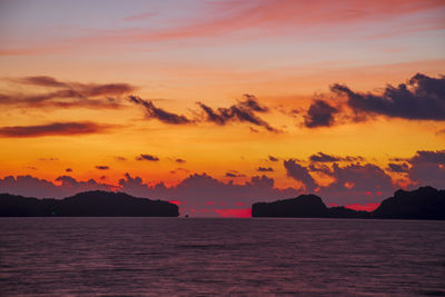 Scenic view of sea against dramatic sky during sunset