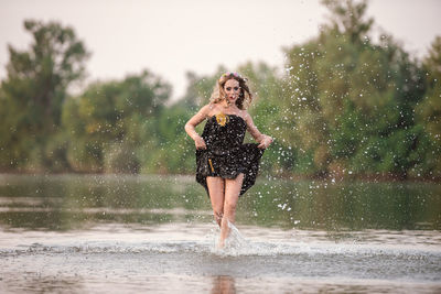 Full length of woman standing in water
