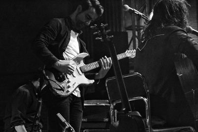 People playing guitar at music concert