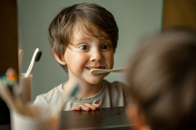 The boy brushes his teeth with a toothbrush made of ecological material