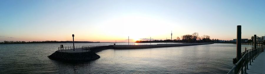 Scenic view of river against clear sky during sunset