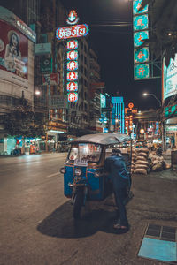 Man on illuminated city street at night