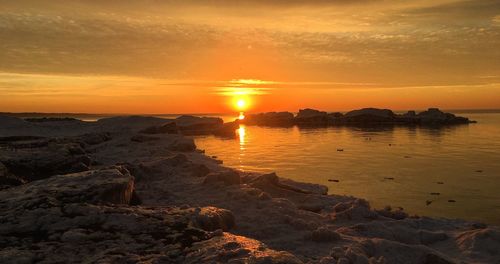 Scenic view of sea against dramatic sky during sunset