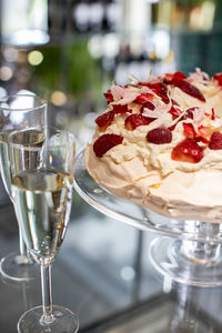 Close-up of champagne flutes by cake on table