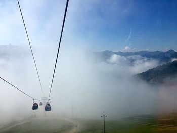 Overhead cable car against sky during foggy weather