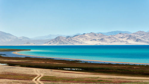 Scenic view of lake and mountains against blue sky