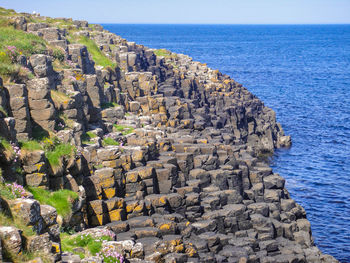 Rock formations by sea against sky