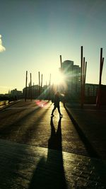 Silhouette of woman walking on street