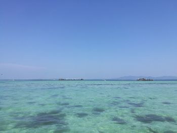 Scenic view of sea against clear blue sky