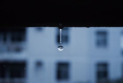 Reflection of building in water dropping from retaining wall