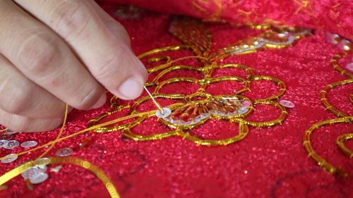Close-up of hand preparing jewelry