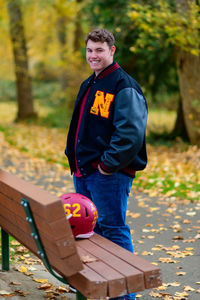 Portrait of boy sitting on bench at park