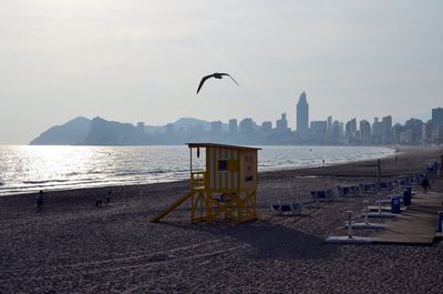 Lifeguard hut at beach against sky