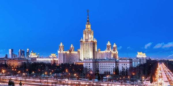 Buildings in city against blue sky