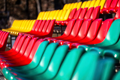 A fragment of the grandstand of an sports stadium with multi-colored seats
