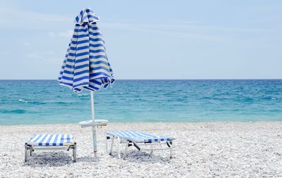 Deck chairs on beach in greece