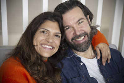 Portrait of smiling mature couple in bedroom at home
