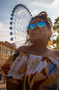 Portrait of young woman wearing sunglasses against sky