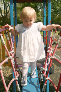 Full length of cute girl standing on slide at playground