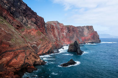 Rock formations by sea against sky