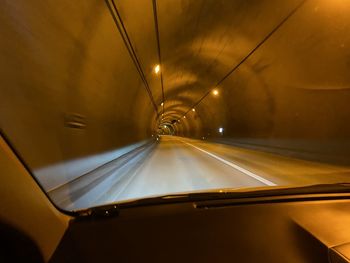 Illuminated tunnel seen through car windshield