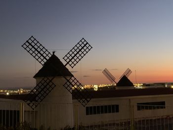 Traditional windmill against sky during sunset