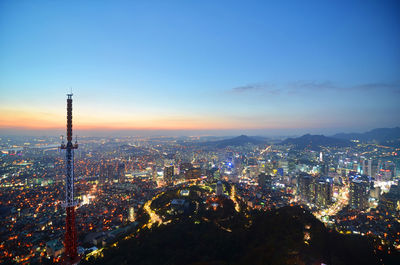 Illuminated cityscape against sky at night