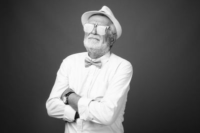 Man wearing hat while standing against black background