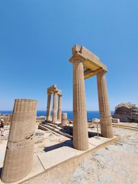 Low angle view of old ruins against clear blue sky