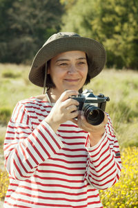 Smiling mature woman holding camera