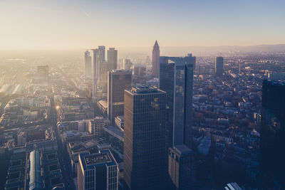 Aerial view of illuminated buildings in city during sunset