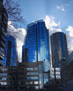 Low angle view of skyscrapers against blue sky