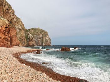 Rocks on beach against sky